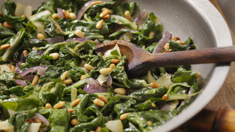 Closeup of sautéed greens with pine nuts in a bowl