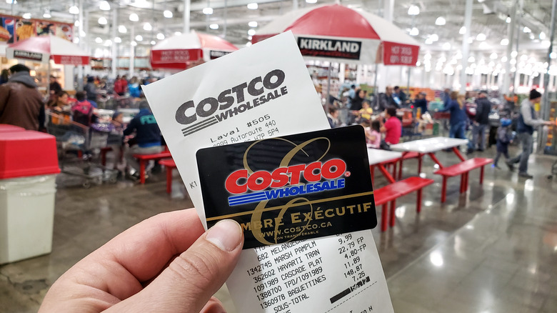 A man holds up his Costco card