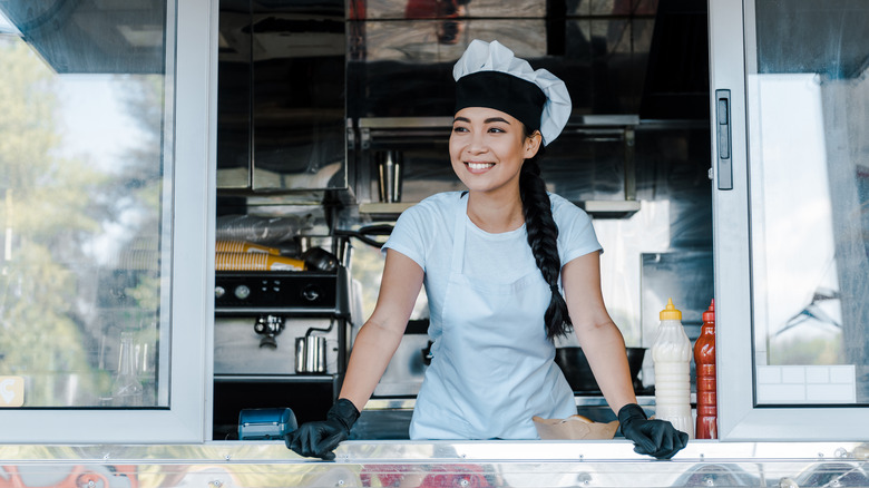 Smiling young woman working food truck