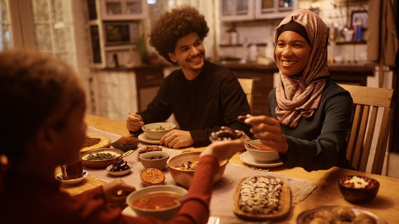 smiling man and woman enjoy dates and other foods with loved ones