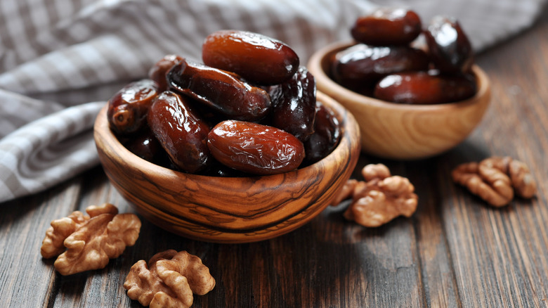 an assortment of dates in two wooden bowls