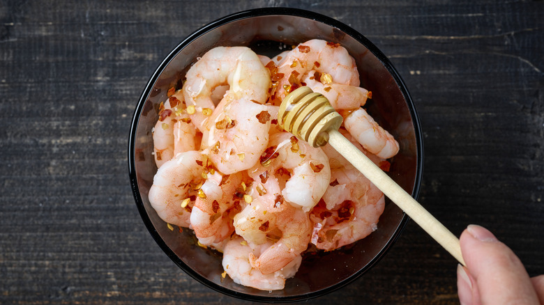 drizzling honey over raw shrimp 