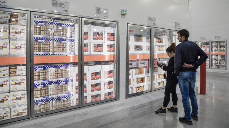 Customers browsing frozen cakes