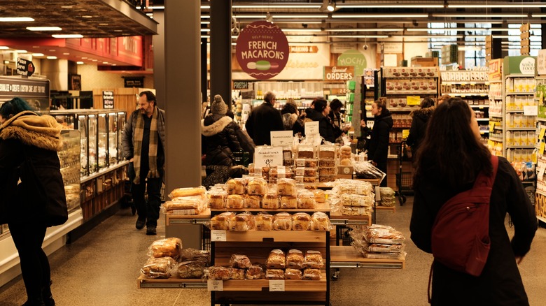 People walking around a bakery section