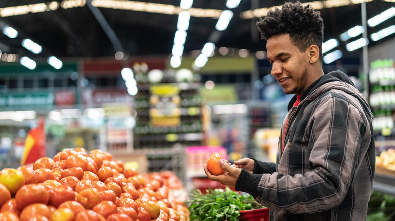 man examines a tomato