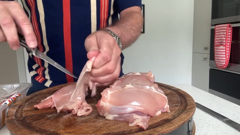 Person removing skin from chicken