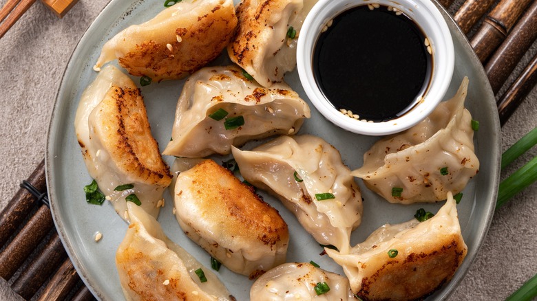 Plate of fried jiaozi with soy sauce