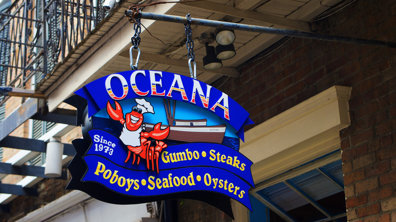 The sign for Oceana restaurant, showing a crawfish in a chef's hat in front of a boat