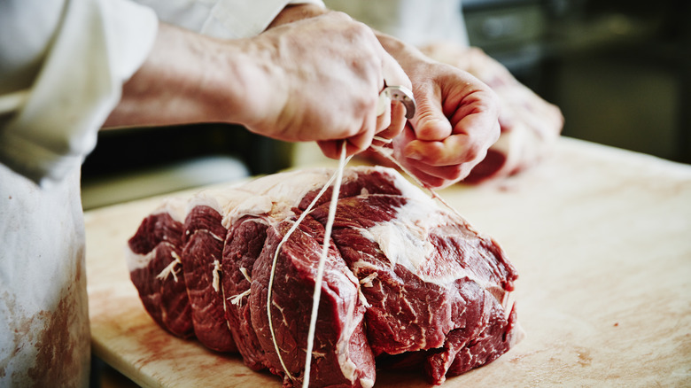 butcher tying cut of beef