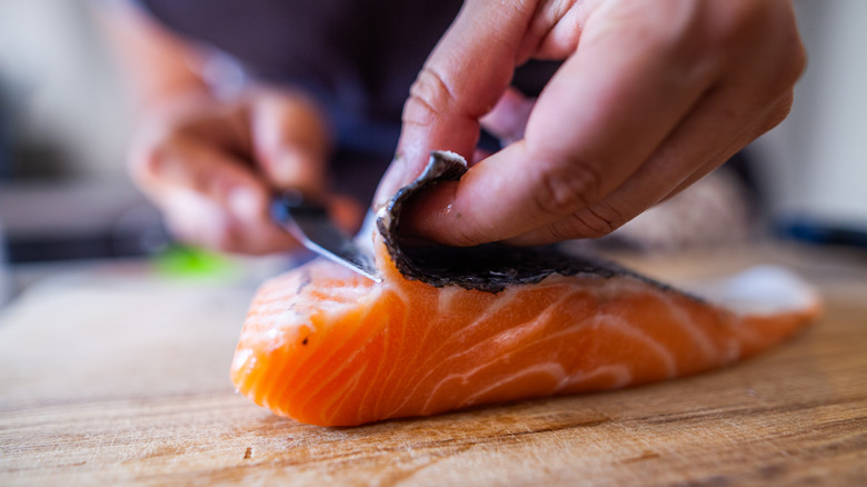 salmon's skin being removed