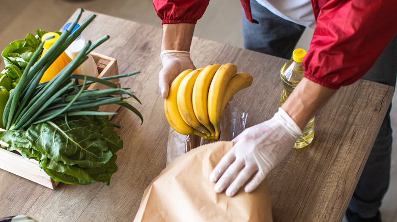 Person taking a bunch of bananas from bag