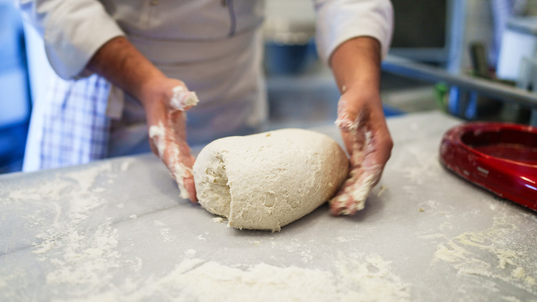 person kneading dough