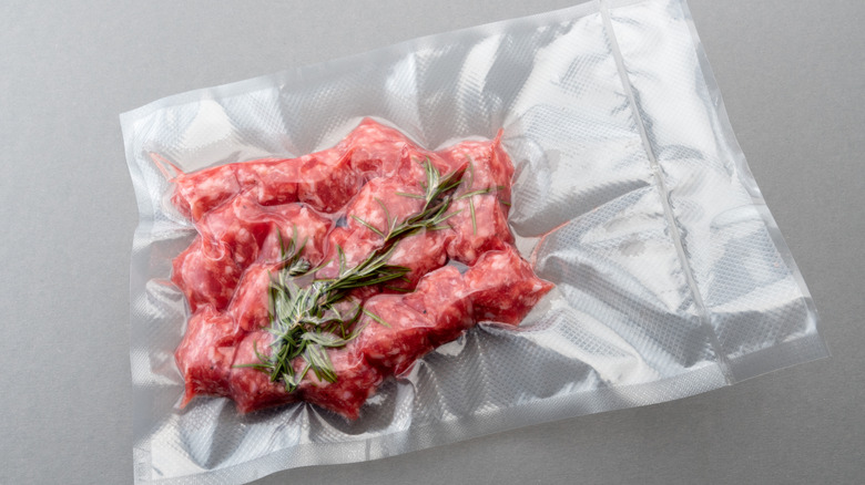 Meatballs and rosemary sealed in vacuum pack ready for sous vide immersion circulator