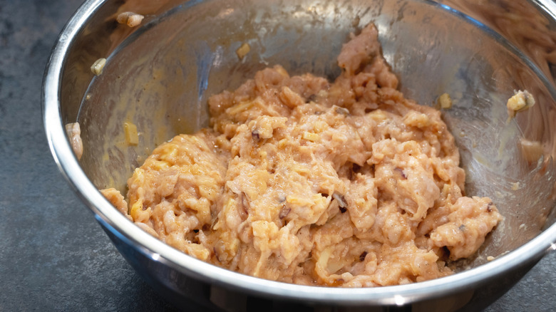 Metal bowl with moist meatball mixture