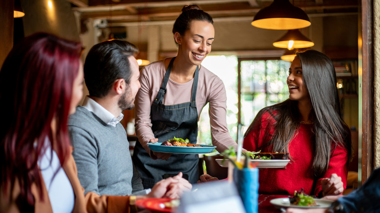 restaurant server placing dishes on table