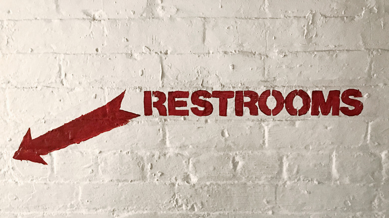 Restroom sign on a brick wall