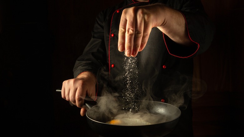 Chef salting eggs