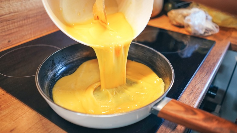 Pouring eggs into pan