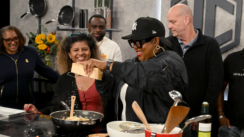 Kardea Brown shreds cheese over a pan at the NYCWFF