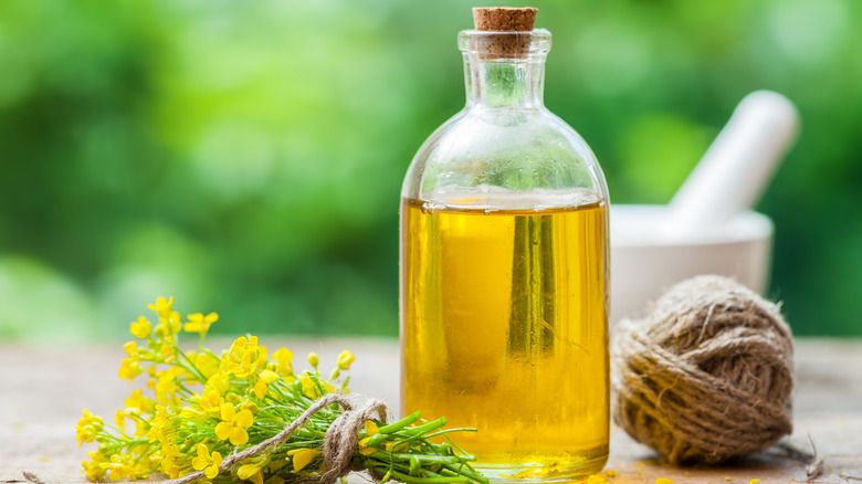 Canola oil in a jar, a ball of yarn, and flowers