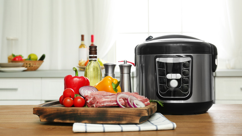 ribs and other ingredients on a cutting board next to a slow cooker