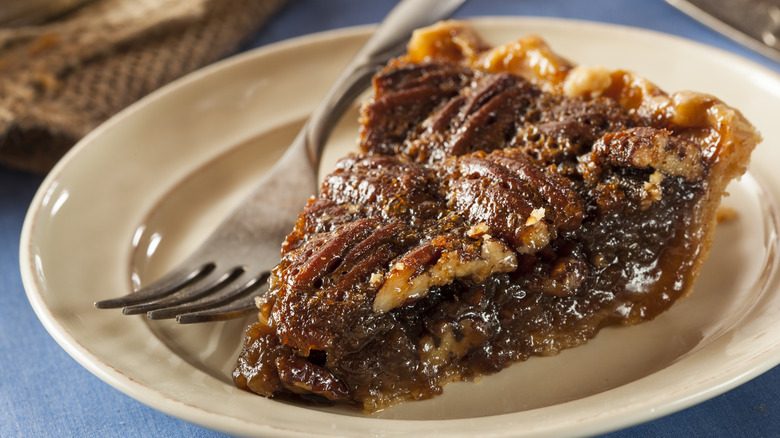 slice of pecan pie on a plate with a fork