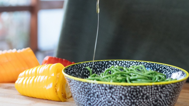 Olive oil being drizzled on green beans