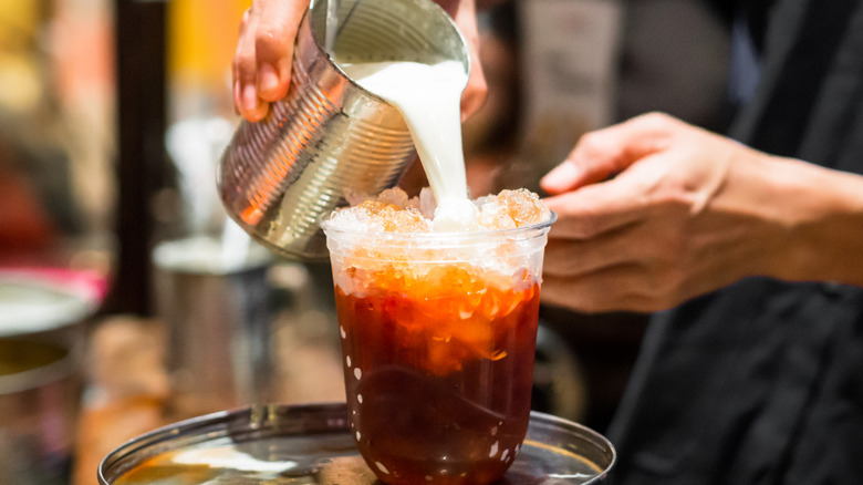 condensed milk poured into Thai tea