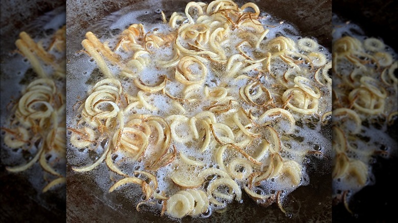 curly fries frying in peanut oil