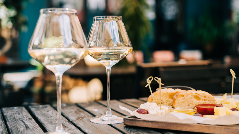 glasses of white wine served with bread and cheese