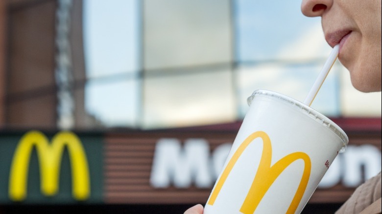 Closeup of person drinking from McDonald's cup with straw