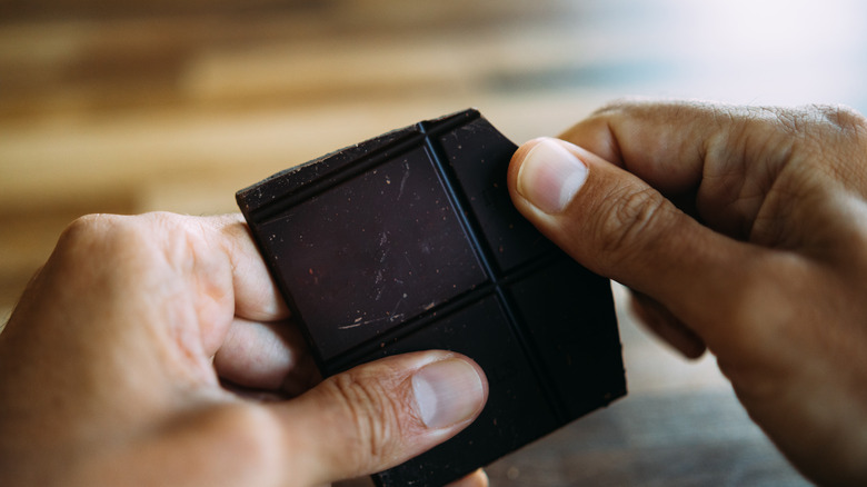 hands breaking dark chocolate