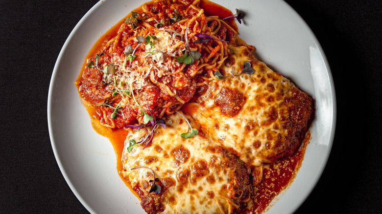 Chicken parm with pasta on white plate