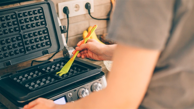 applying grease to waffle iron