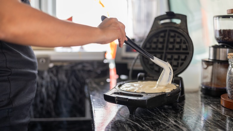 pouring batter into waffle maker