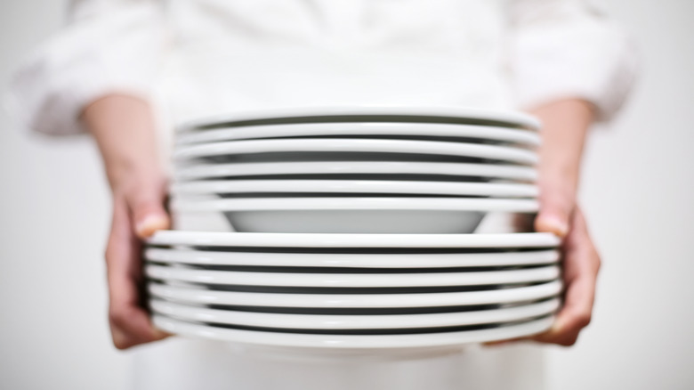 Stack of plates held by waiter