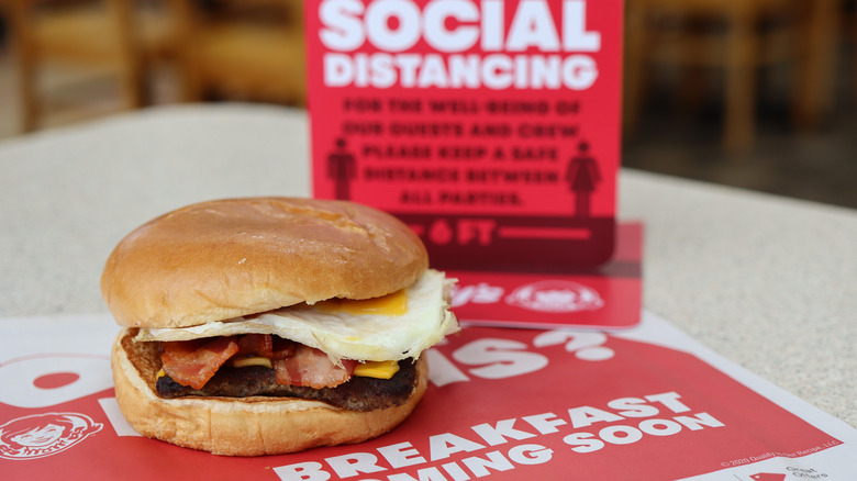 Wendy's breakfast Baconator sandwich on table