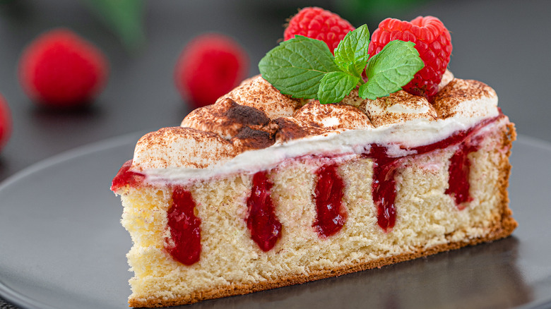 Slice of poke cake with raspberries