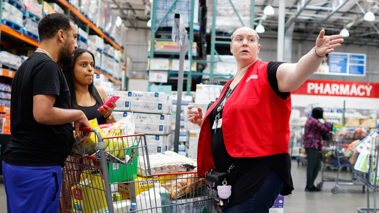 Costco employee helping shoppers in store