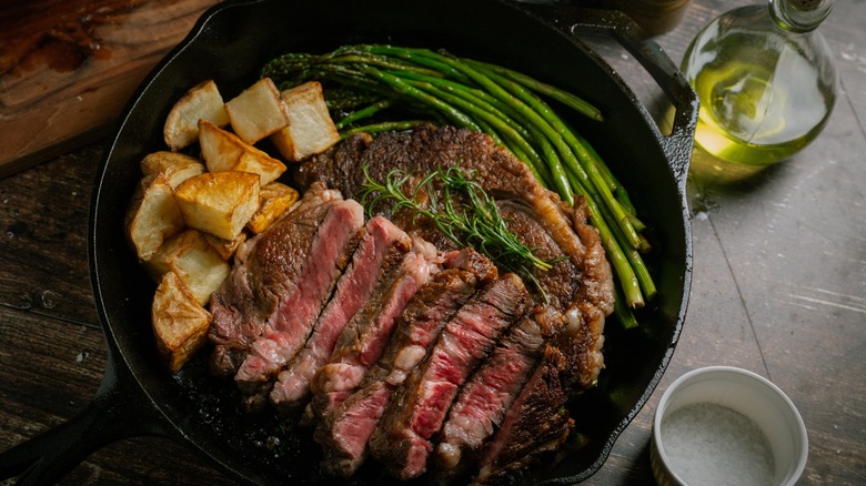 steak, potatoes, and green beans in skillet