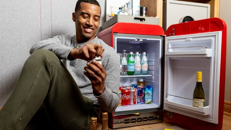 Man beside a minifridge