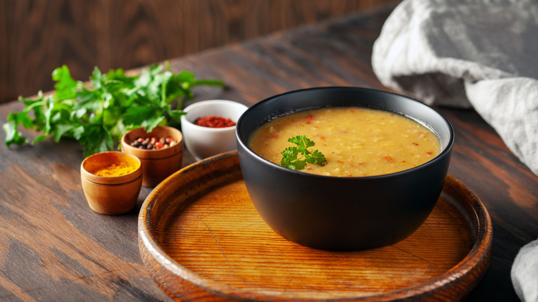 Curry in a bowl next to herbs and spices