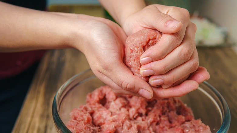 person shaping burger patties