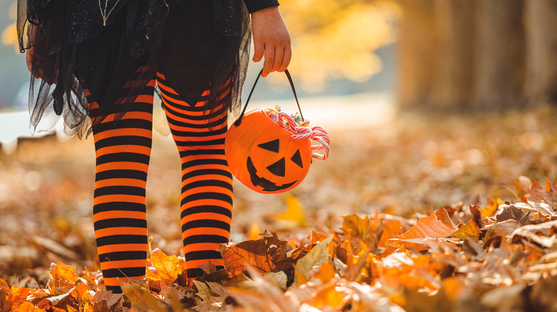 child in striped leggings trick-or-treating