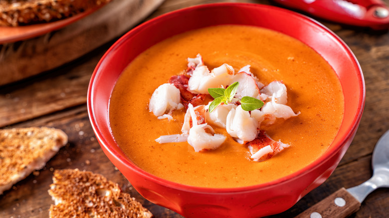 Creamy lobster bisque in bowl and bread