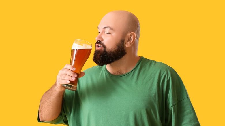 Bald man about to sip beer