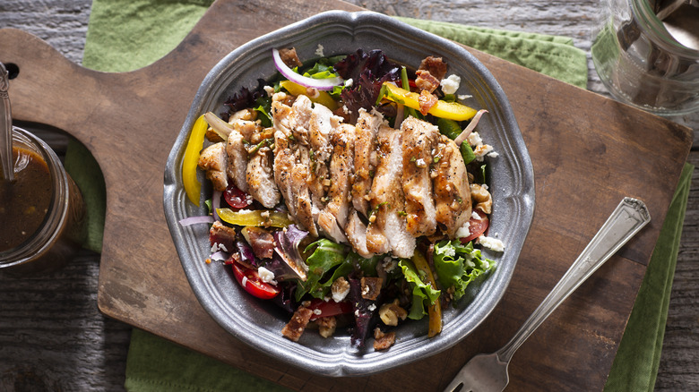 Salad with chicken on wooden board