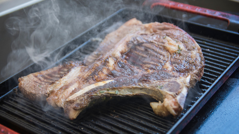 Steak smoking on grill 