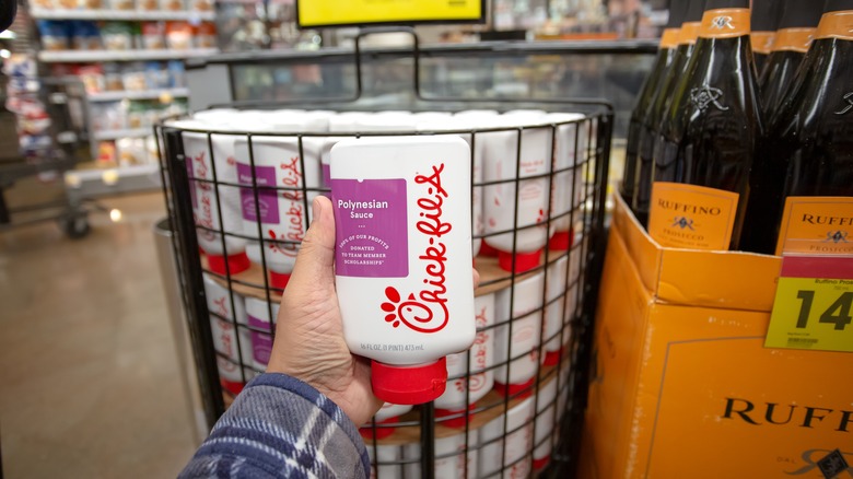 A man holds a bottle of Chick-fil-A Polynesian Sauce