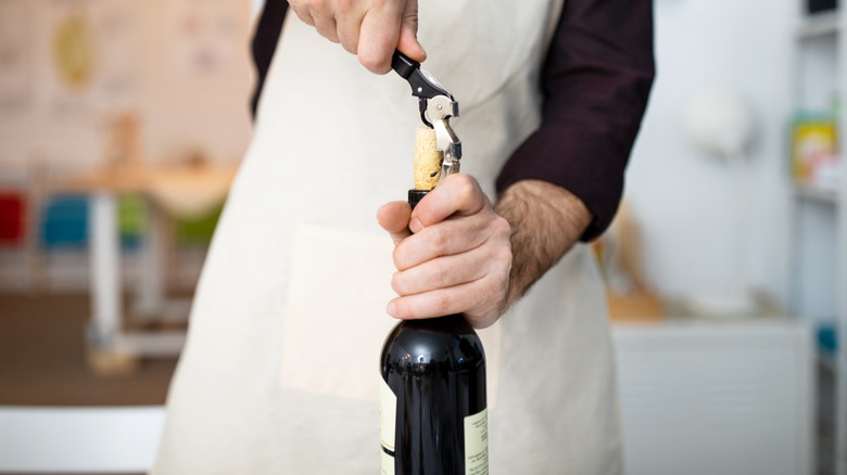 Person taking cork out of bottle